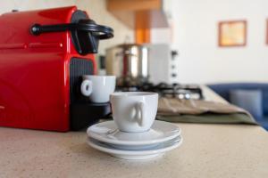 ラ・カレッタにあるPorto Apartments - La Calettaのコーヒーメーカーの横のカウンターに2杯
