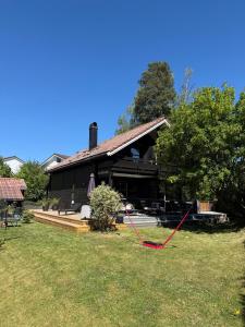 a black house with a red string in the yard at Idyllic Island Home 15 Min from Oslo in Asker