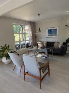 a living room with a couch and a table and chairs at Idyllic Island Home 15 Min from Oslo in Asker