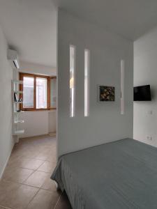 a bedroom with a bed in a white wall at Casa Fiorenza - Da e Nònne in Carloforte