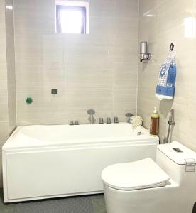 a bathroom with a white tub and a toilet at Nhà Nghỉ Hưng Hà in Kon Rung (1)