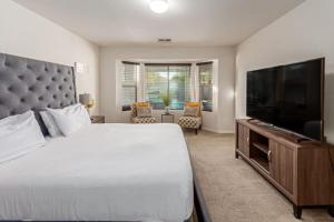 a bedroom with a large bed and a flat screen tv at Beautifully Decorated HomeAvondalePrivatePool in Avondale