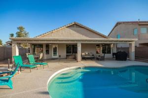a house with a swimming pool and chairs next to a house at Beautifully Decorated HomeAvondalePrivatePool in Avondale