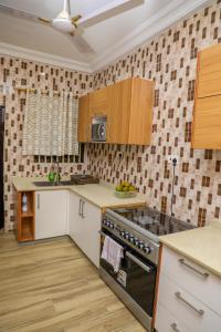 a kitchen with white cabinets and a stove top oven at Capricorn Heights BnB 2 bedrooms Apartment at Kwabenya, Accra, Balloon Gate in Kwabenya