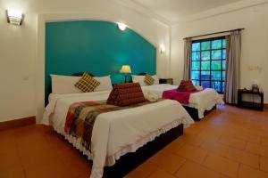 a bedroom with two beds and a green wall at Sonalong Boutique Village & Resort in Siem Reap