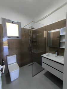 a bathroom with a toilet and a sink and a shower at KAFUL APARTMENTS in Qeparo