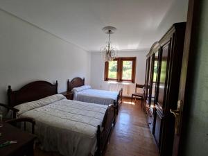 Un dormitorio con dos camas y una ventana. en Casa García, Cantabria, en Pesquera 22 fotos más