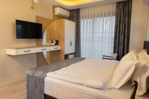 a hotel room with a bed and a television at New City Otel in Osmaniye