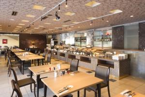 钏路钏路世纪城堡酒店 的有木桌椅和酒吧的餐厅