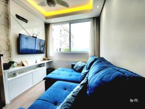 - un salon avec deux canapés bleus et une télévision dans l'établissement Xingu Reserva Ipanema, à Porto Alegre