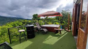 a balcony with a table and chairs and an umbrella at Glamping Entre Rocas Tena in Tena