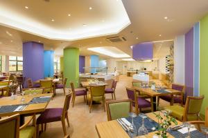 a restaurant with wooden tables and chairs and purple walls at Solimar Ruby in Malia