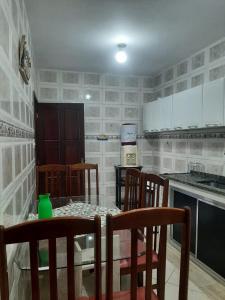 a kitchen with a glass table with chairs and a counter at Casa em Mangaratiba RJ - 40 metros da Praia in Mangaratiba