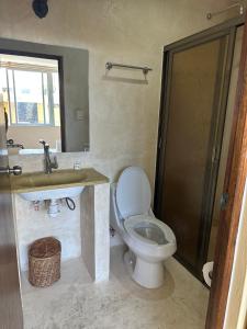 ein Badezimmer mit Toilette und Waschbecken in der Unterkunft Puul Suites in Mérida