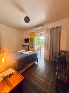 a bedroom with a bed and a table and a table at Pousada Brisa Do Porto in Porto De Galinhas
