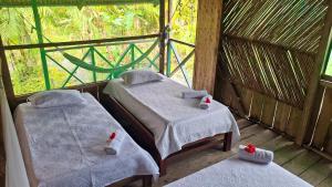 a room with two beds with towels on them at Ecoposada Nore in Nuquí