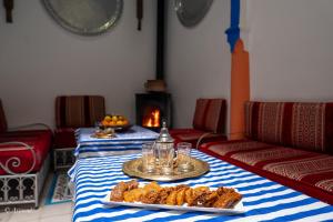 a room with two tables with food and a fireplace at Riad Alia Suites SPA in Chefchaouene