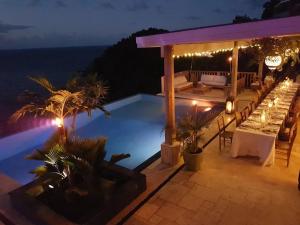 a pool with a table and a bar at night at House of Rogues in Tortola Island
