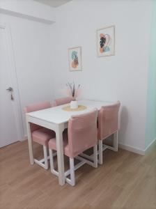 a white table and chairs with a vase on it at Apartamento Murales de Talavera in Talavera de la Reina