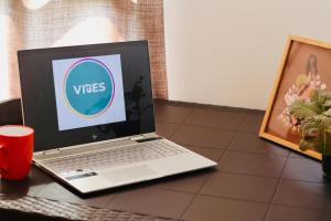 a laptop computer sitting on a table with a red cup at Vibes Wellness House in Tamanique