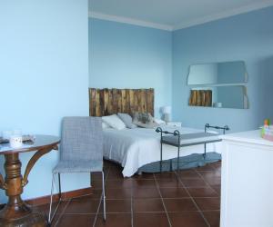 Dormitorio azul con cama, mesa y silla en b&b I Limoni, en Ravello