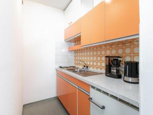 a kitchen with orange and white cabinets at Brixen Alpin Living Top 7 in Brixen im Thale