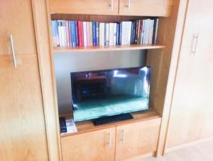 a entertainment center with a tv in a book shelf at Haus an der Therme in Bad Endorf +21 photos