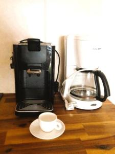 a coffee maker and a coffee cup on a counter at Haus an der Therme in Bad Endorf