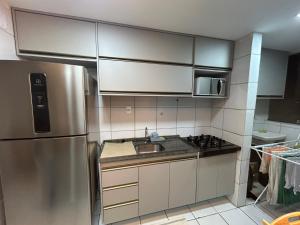 a kitchen with a stainless steel refrigerator and a sink at Perfeito Ap Caruaru in Caruaru