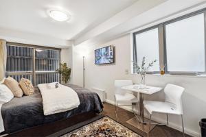 a bedroom with a bed and a table and chairs at Cityscape on White - Auckland Central Studio in Auckland