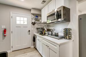 une cuisine avec des armoires blanches et un micro-ondes dans l'établissement Cheverly Apartment - 4 Mi to Commanders Field!, à Landover