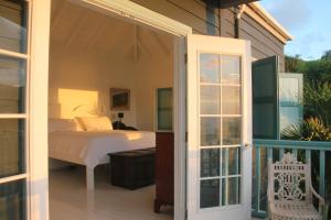 a bedroom with a bed and a sliding glass door at Lowena Cottage in Tortola Island