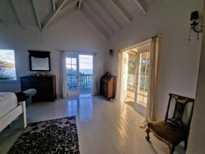 a living room with a couch and a chair and a television at Lowena Cottage in Tortola Island