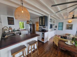 a kitchen with a counter and a table in a room at Lowena Cottage in Tortola Island +19 photos