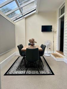 a dining room with a table and chairs on a rug at Location, Location, Location in Launceston