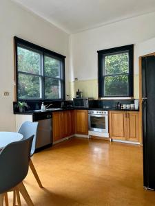 a kitchen with wooden cabinets and a black refrigerator at Location, Location, Location in Launceston +5 photos