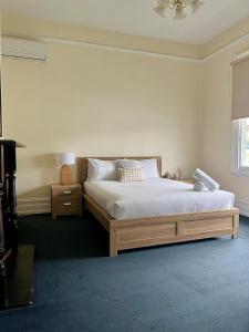 a bedroom with a bed and a table and a window at Location, Location, Location in Launceston