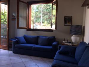 a living room with blue couches and a window at Villa Giuliana in San Vito lo Capo