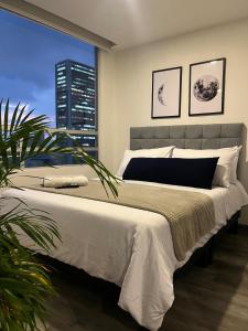 a bedroom with a large bed with a large window at Panoramic Luxury of Bogotá in Bogotá