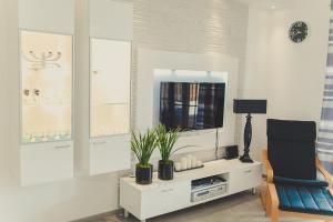 a living room with a tv and a chair at Apartament Nadmorski - Rogowo in Rogowo