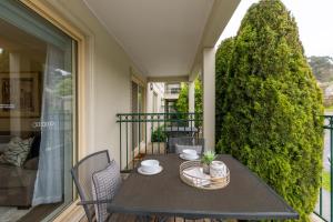 a table on a balcony with a tree at Lifestyle Apartments at Ferntree in Fern Tree Gully