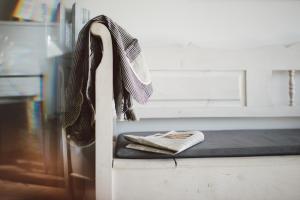 ein Paar Schuhe und eine Zeitung auf dem Bett in der Unterkunft meerzeit Hotel in Cuxhaven