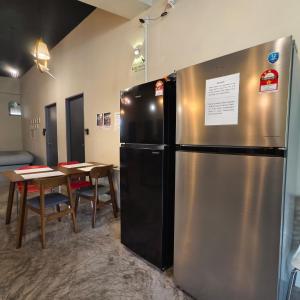 a large stainless steel refrigerator in a room with a table at Wayton Cottage in George Town