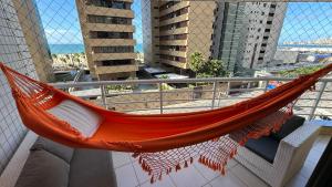 an orange hammock on a balcony in a building at Atlantic Ocean Residence in Fortaleza