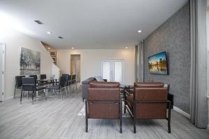 a living room with chairs and a dining room at Stylish 5-Bedroom Villa - Perfect Disney Getaway! in Davenport