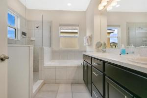 a bathroom with a tub and a sink and a shower at Stylish 5-Bedroom Villa - Perfect Disney Getaway! in Davenport +32 photos