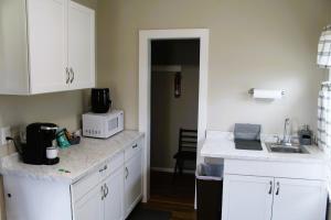 a kitchen with white cabinets and a sink and a microwave at Peaceful Family Retreat with Games and Glamping! in Livingston +10 photos