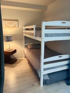 a bedroom with two bunk beds and a lamp at Le Céleste mountain view 4 beds in Beaupré