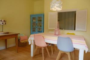a dining room with a table with chairs and a blue cabinet at Albatros C0 in De Haan