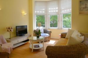 a living room with a couch and a tv at Albatros C0 in De Haan
